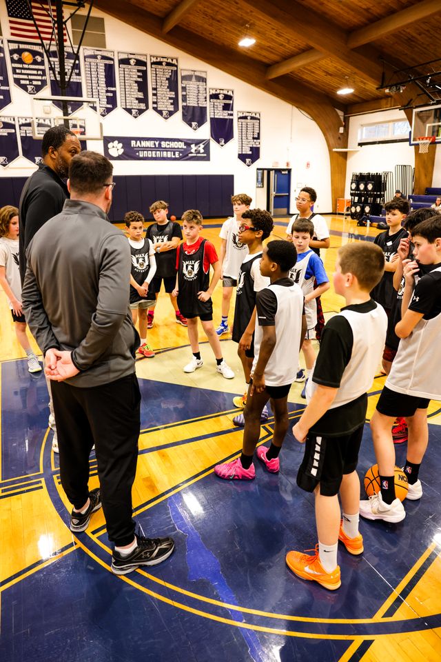 Coaches and players inside a huddle during practice