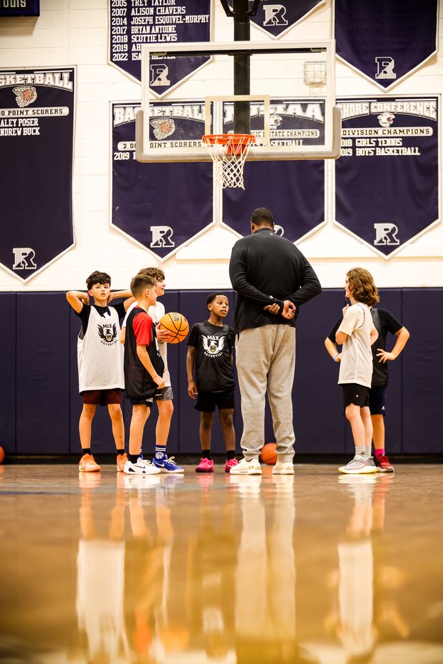 A coach and players gathered on the court at Ranney School